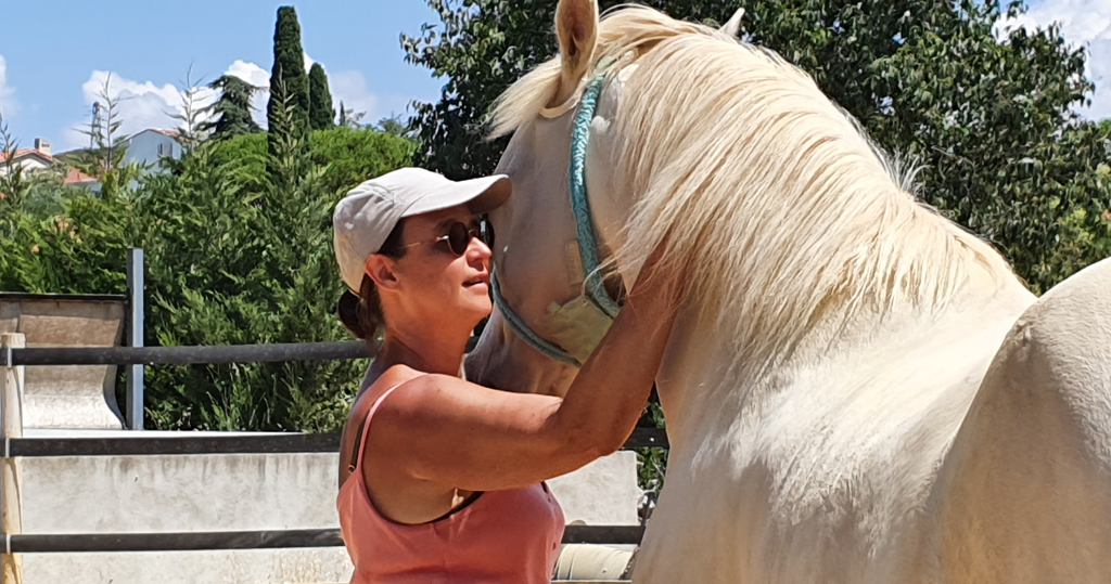 Anne caressant un cheval blanc